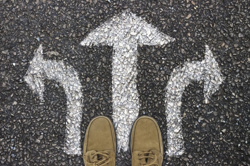 靴を履いた足と三方向の矢印が描かれた白線