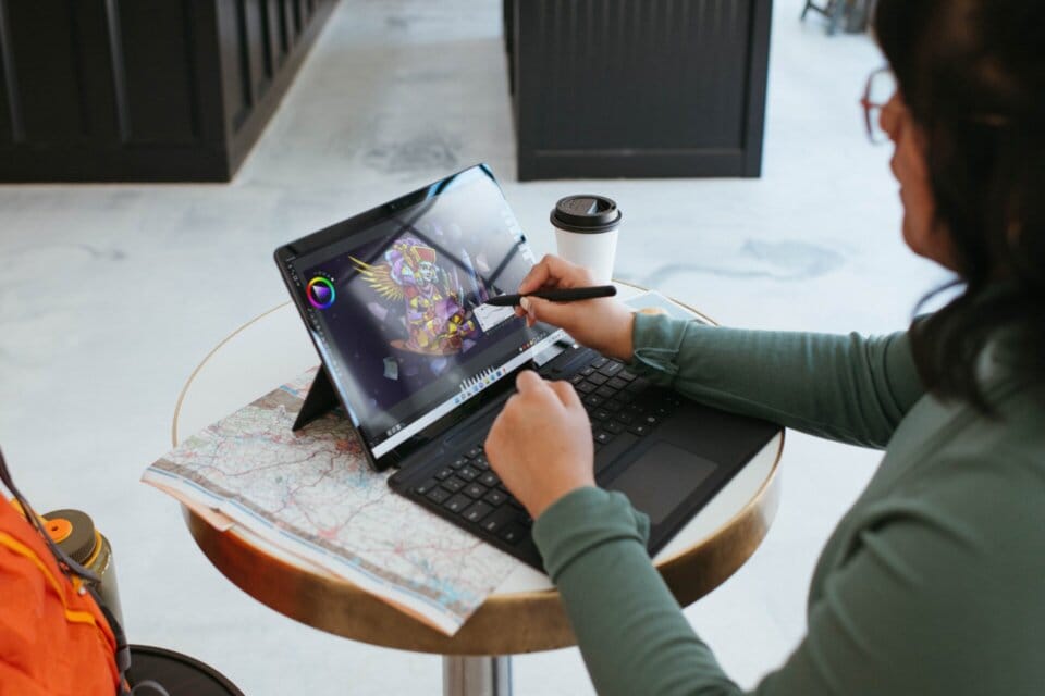 ノートパソコンの画面にペンで操作する女性