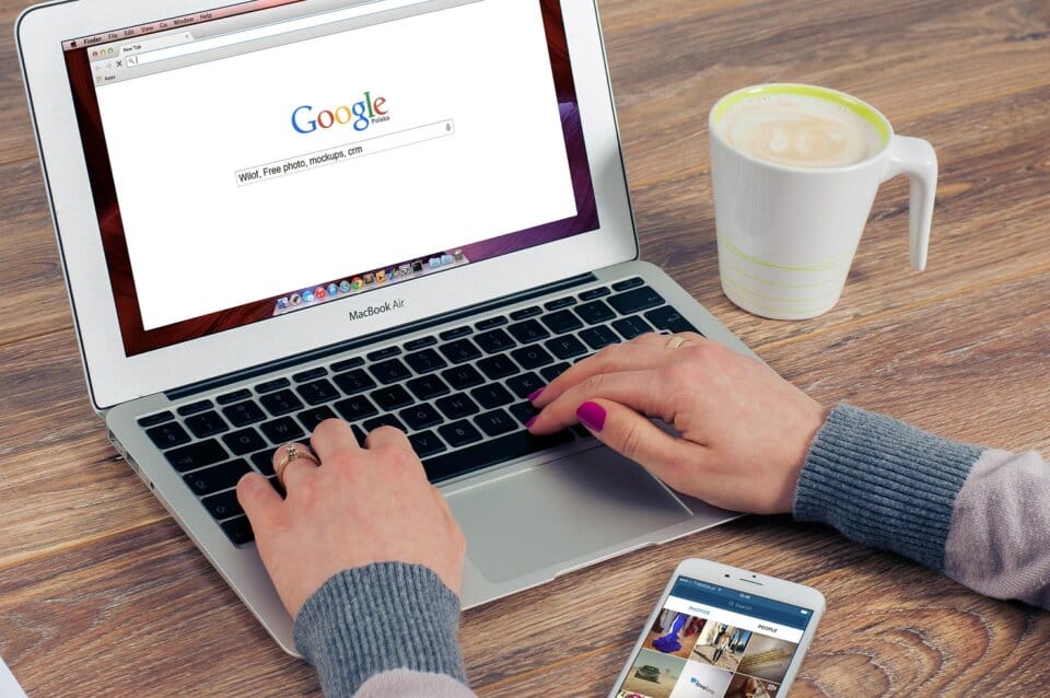 ノートパソコンにGoogle検索画面、女性がキーボードを打っている